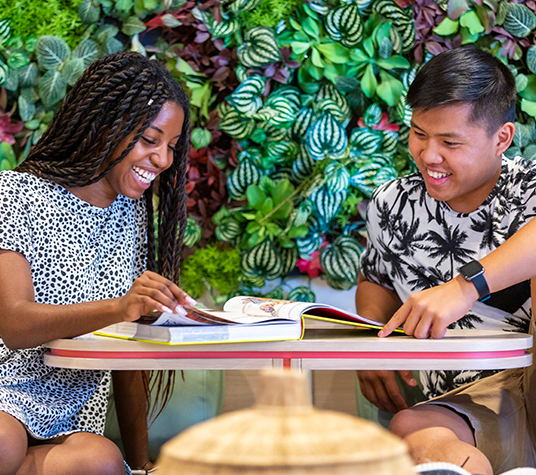 Two friends reading a book